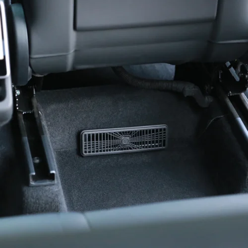 Rectangular car floor vent/grille under the dashboard near the driver's seat area for airflow
