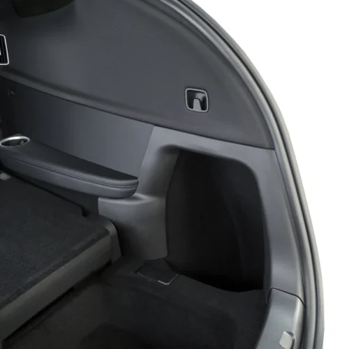 Close-up of a car's rear cargo area: side panel with a small square latch, black upholstery, and a cup holder along the edge.