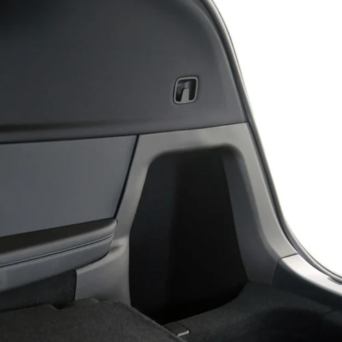 Small recessed hatch release handle on the car's cargo-area side panel.