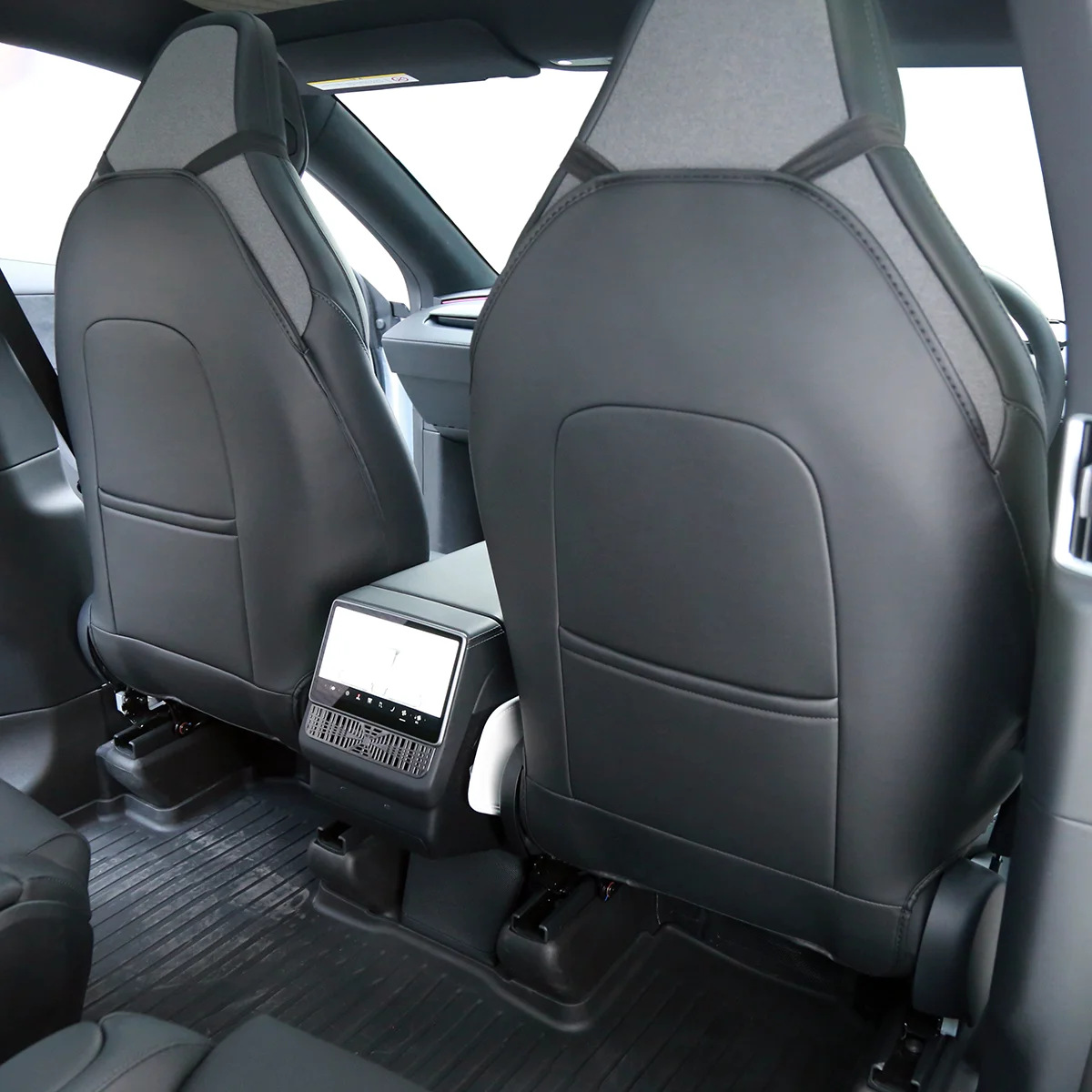Interior of a car's rear seating area focusing on the two front seats and center touchscreen console between them