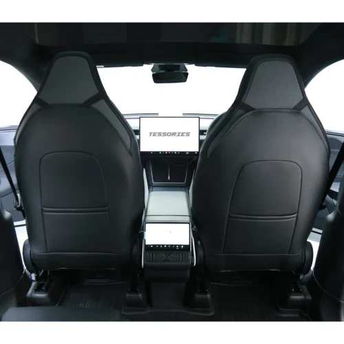 Rear-view inside a modern car: two black leather front seats with high backs, center console, and a dashboard screen showing 'TESSORIES'.