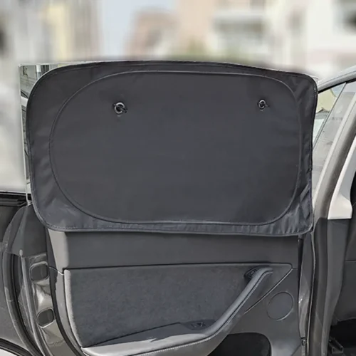 Open car door showing a large black sunshade pulled up over the rear window, obscuring the passenger area in the car interior.