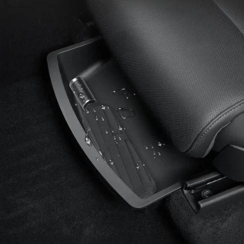 Close-up of a folded seat belt tucked into a car seat base, with water droplets on the belt and surrounding surface
