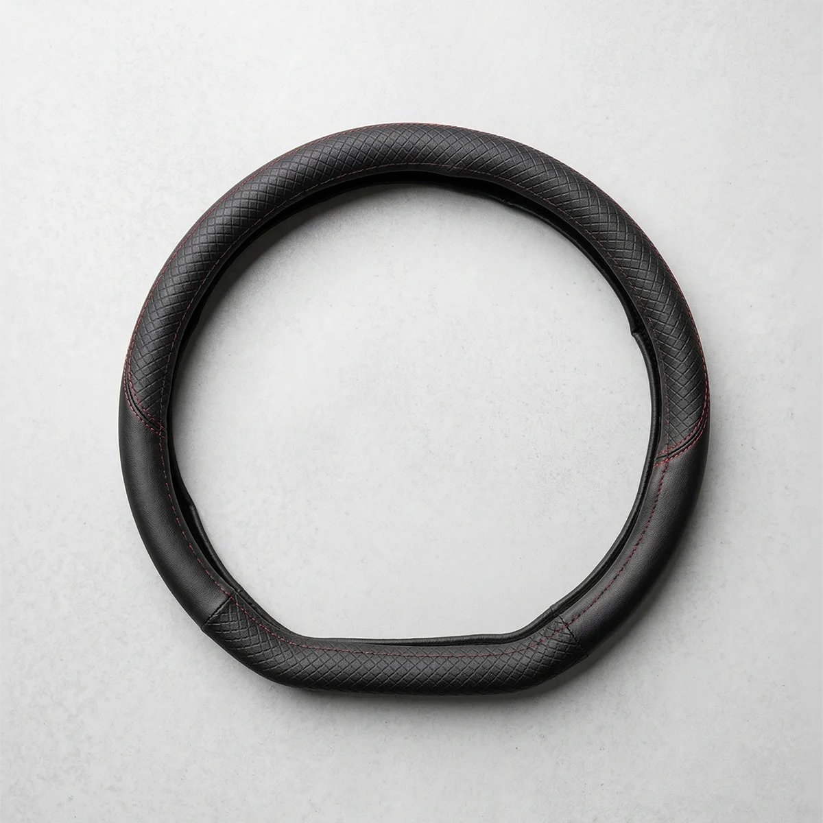 Black textured leather steering wheel cover with red stitching, displayed on a light gray background.