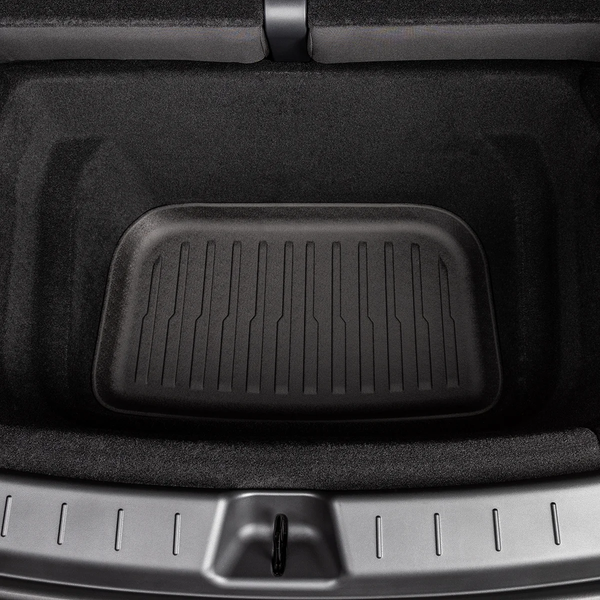 Car trunk cargo area with a black rubber mat covering the floor