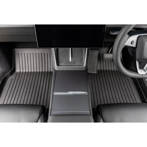Modern car interior featuring a large central touchscreen above the center console and ribbed floor mats on both sides of the aisle.