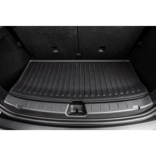 Car trunk interior with a textured black cargo mat covering the floor between the rear seats and tailgate edge.