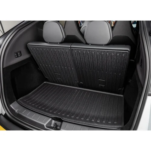 Open hatchback trunk showing folded rear-seat backs and a ribbed rubber cargo mat on the floor, ready for loading.