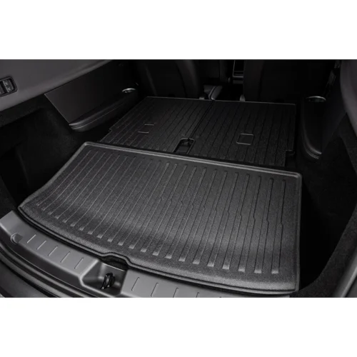 Rear cargo area of a vehicle with layered rubber floor mats laid flat for extra storage