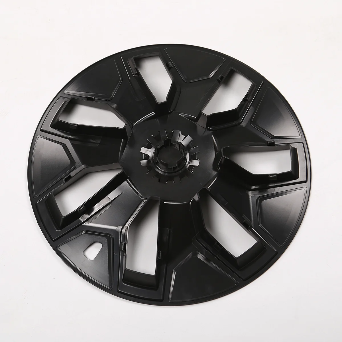Black plastic circular wheel hub with eight wide spokes and a gear-like center on a white background.