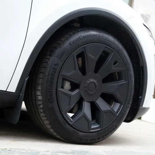 Close-up of a white car's wheel with a dark alloy rim and a Continental EcoContact 7S tire.